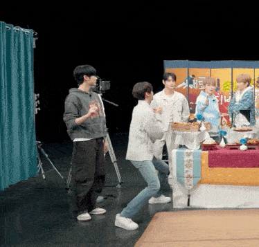 a group of young men are standing around a table with a sign on it that says ' a ' on it