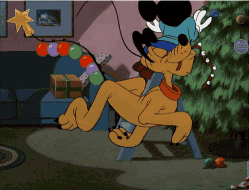 mickey mouse and pluto are decorating a christmas tree with a star