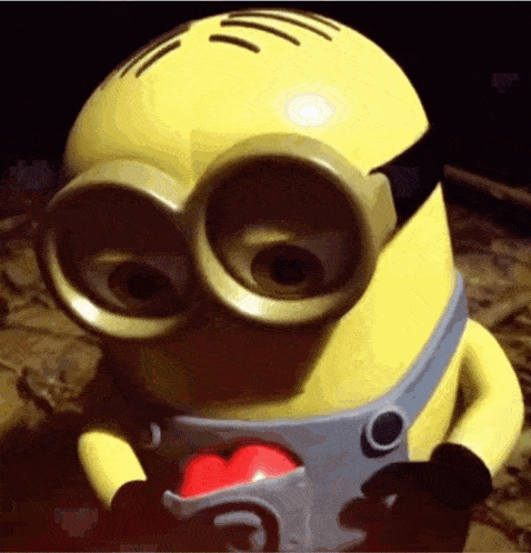 a close up of a toy minion with a red heart in his mouth
