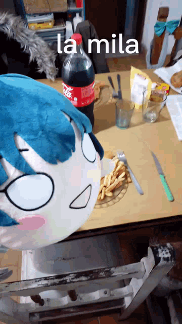 a stuffed animal is sitting at a table with a coca cola bottle