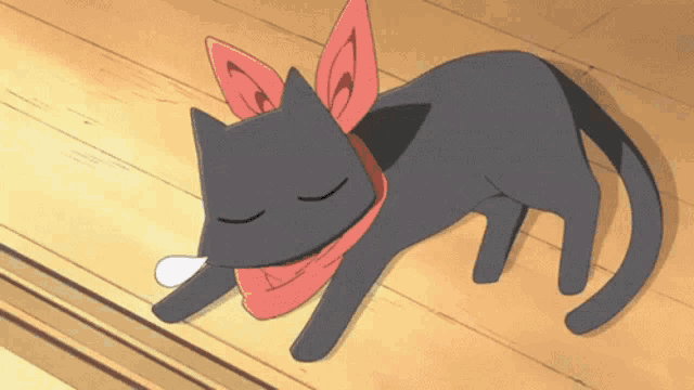 a black cat with a red scarf around its neck is sleeping on a wooden floor