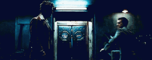 two men are standing next to each other in front of a door that says dump on it .