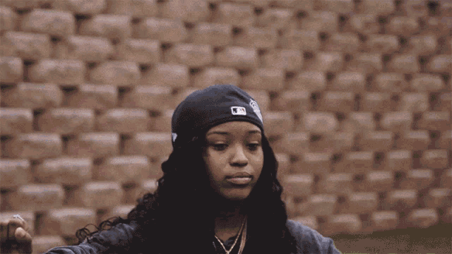 a woman wearing a hat with a mlb logo on it