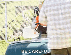a man is standing next to a golf cart with the words `` be careful '' written on the side .