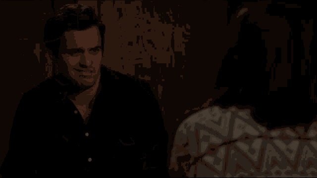 a man in a black shirt is talking to a woman and the word sexy is visible