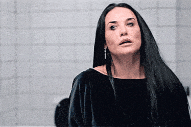 a woman with long black hair is wearing a black top