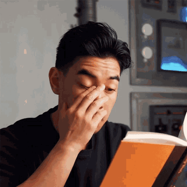 a man covering his face while reading a book called " a brief history "