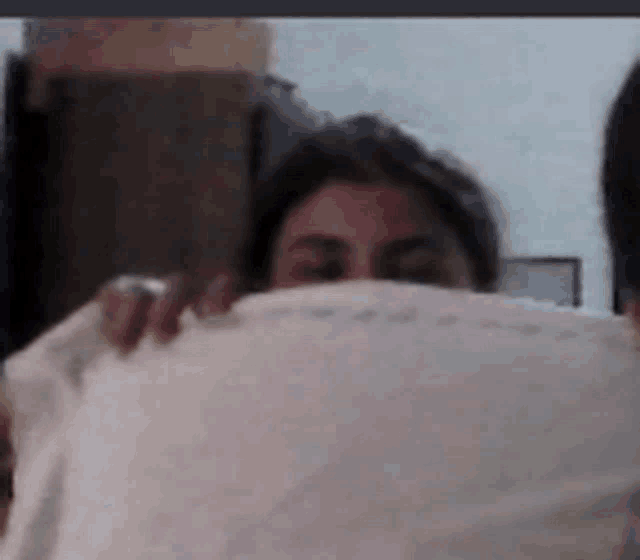 a person covering their face with a white cloth