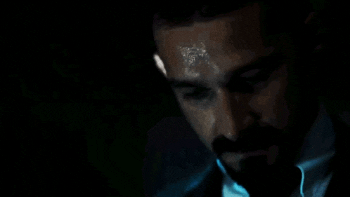 a man with a beard wearing a suit and tie is sweating