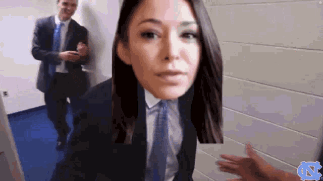 a woman in a suit and tie is standing next to a man in a suit and tie