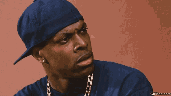 a man wearing a blue hat and a chain around his neck is covering his nose .