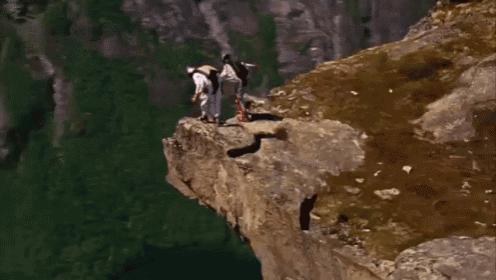 a person is jumping off a cliff into a body of water