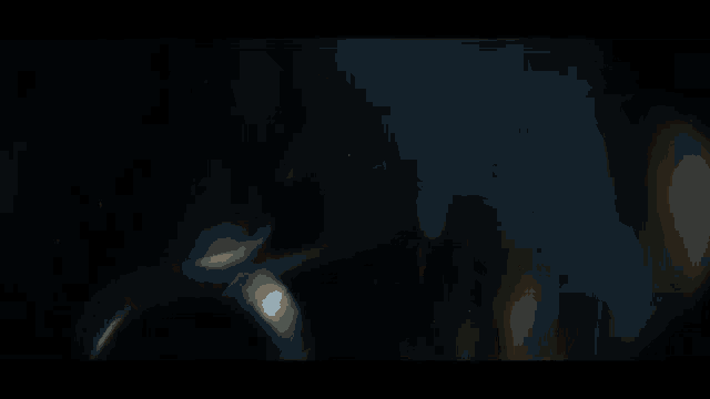 a dark room with a few lights coming through the window