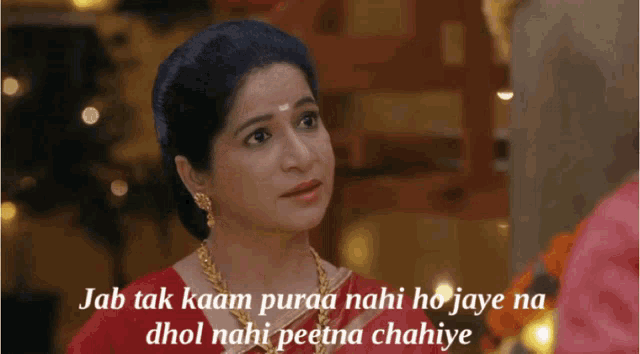 a woman in a red dress with the words jab tak kaan puraa nahi ho jaye na dhol nahi peetna chahiye written below her