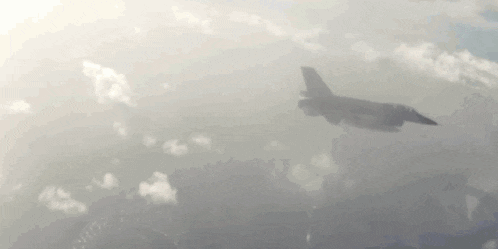 a fighter jet is flying through the clouds .