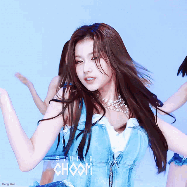 a woman in a blue dress is dancing in front of a studio sign