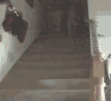 a little girl in pink pajamas is walking down stairs .