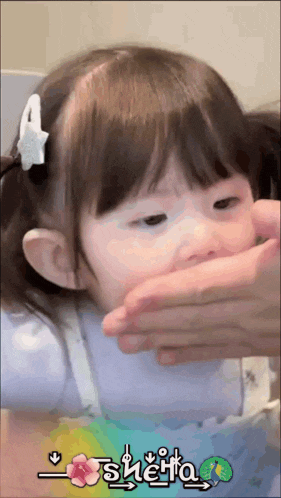 a little girl with a star in her hair is being held by a person