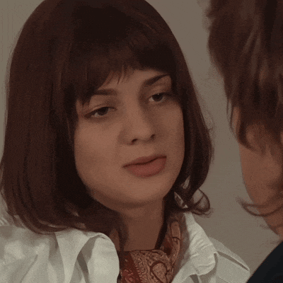 a close up of a woman 's face with a white shirt on