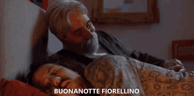 a man and woman are laying in bed with the words buonanotte fiorellino above them