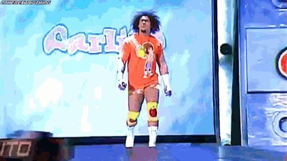 a wrestler is walking on a stage in front of a sign that says cartoon network .