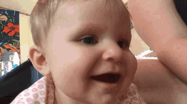 a close up of a baby 's face with its mouth open