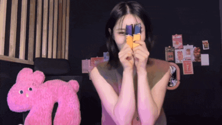 a woman is holding a card in front of her face