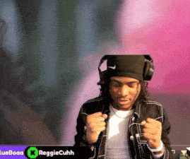 a man wearing headphones and a black hat with the name reggiecuhh