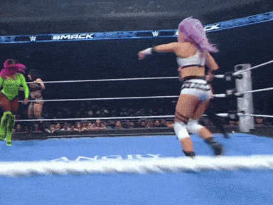two women are wrestling in a wrestling ring with a banner that says mack on it