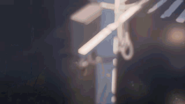 a blurred image of a cross with scissors cutting it