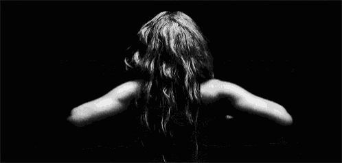 a black and white photo of a person flying through the air in the dark .