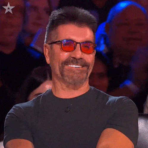 a man wearing sunglasses and a black shirt with a star on the bottom right