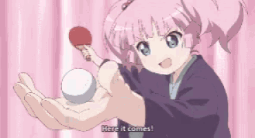a girl with pink hair is holding a ping pong paddle and a ball with the words here it comes below her