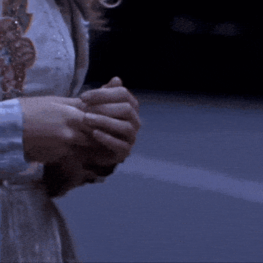 a person in a white dress is holding a cell phone in their right hand