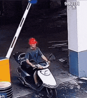 a man wearing a red hard hat is riding a white scooter