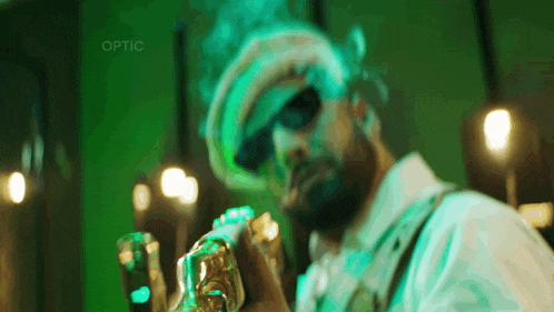 a man wearing sunglasses and a hat is holding a trophy with the word optic above him