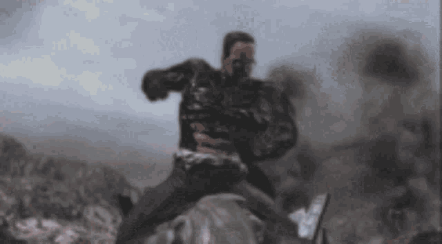 a blurry picture of a man riding a horse in the desert