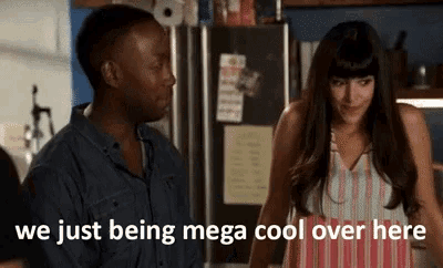 a man and a woman are standing next to each other in a kitchen with the words we just being mega cool over here above them .