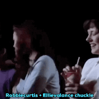a group of people are sitting in a dark room and clapping .