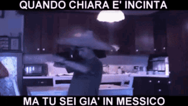 a man wearing a sombrero is dancing in a kitchen .
