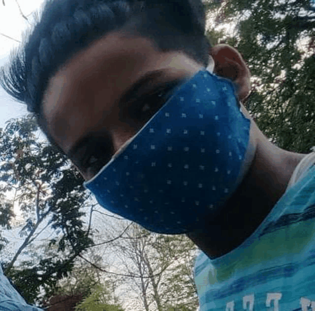 a man wearing a blue face mask is taking a picture of himself .