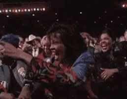 a group of people are sitting in a dark room with the words " esa es mi chica " written above them