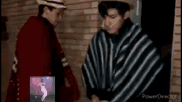 a man in a striped poncho is standing next to another man in a red coat