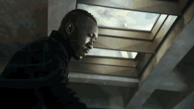 a man in a black suit looks up at the sky