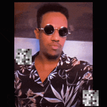 a man wearing a floral shirt and round sunglasses