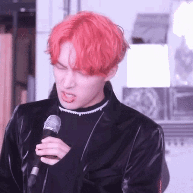 a man with red hair is holding a microphone in his hand .