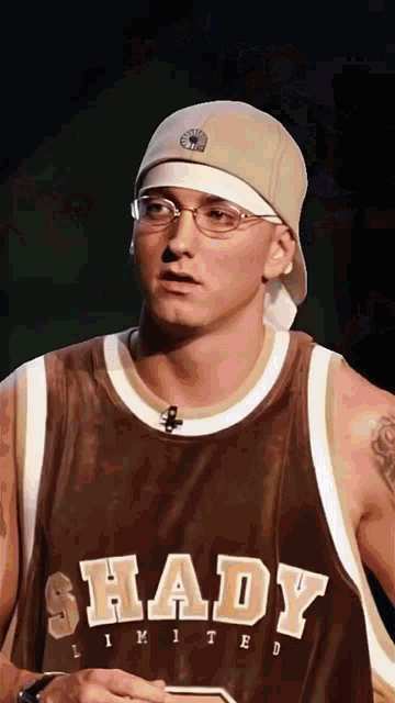 a man wearing a shady limited jersey and a hat