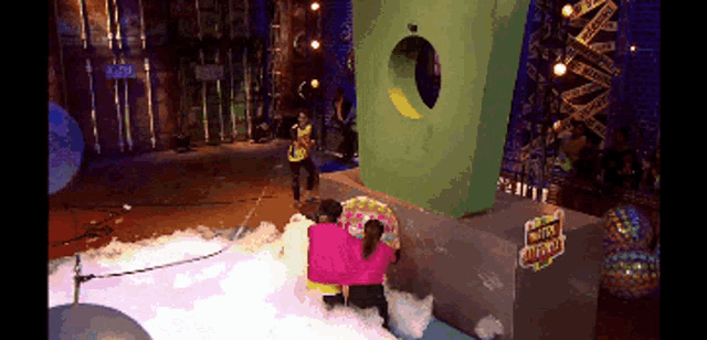 a group of people standing in front of a giant green box that says bubble blast