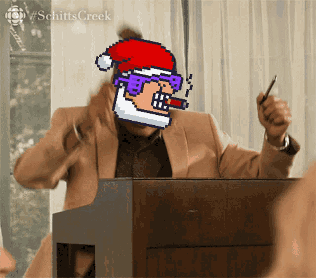 a man wearing a santa hat is sitting at a podium
