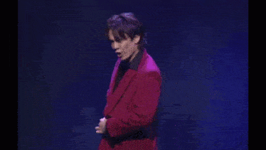 a person wearing a black shirt with chinese writing on the back is dancing on a stage .